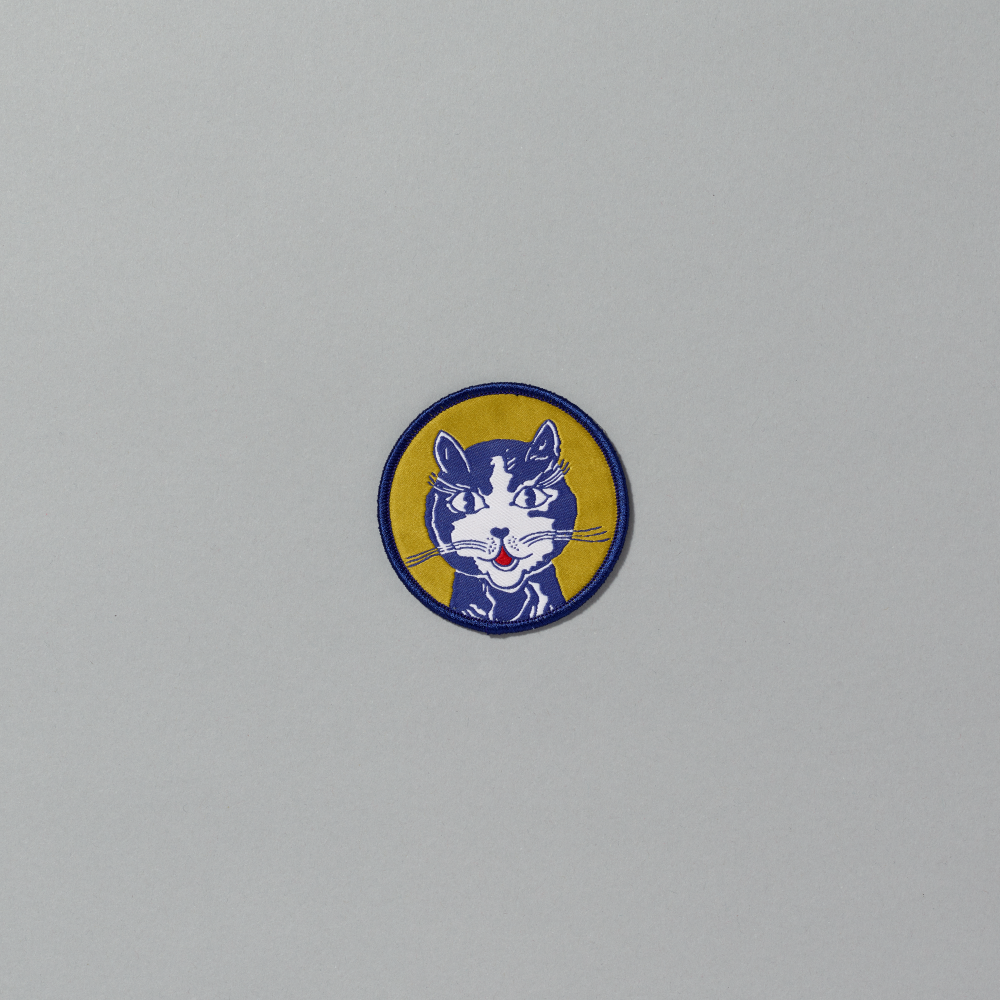 Embroidered iron-on patch featuring Roy Lichtenstein's Laughing Cat against a gray background