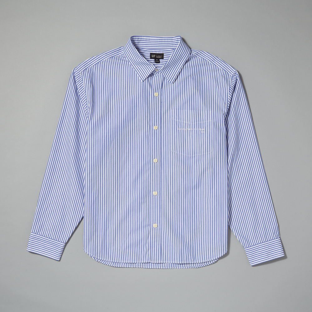 A long-sleeve button-down shirt with thin vertical blue and white stripes, featuring a classic collar, white buttons, and a single chest pocket, laid flat against a neutral gray background