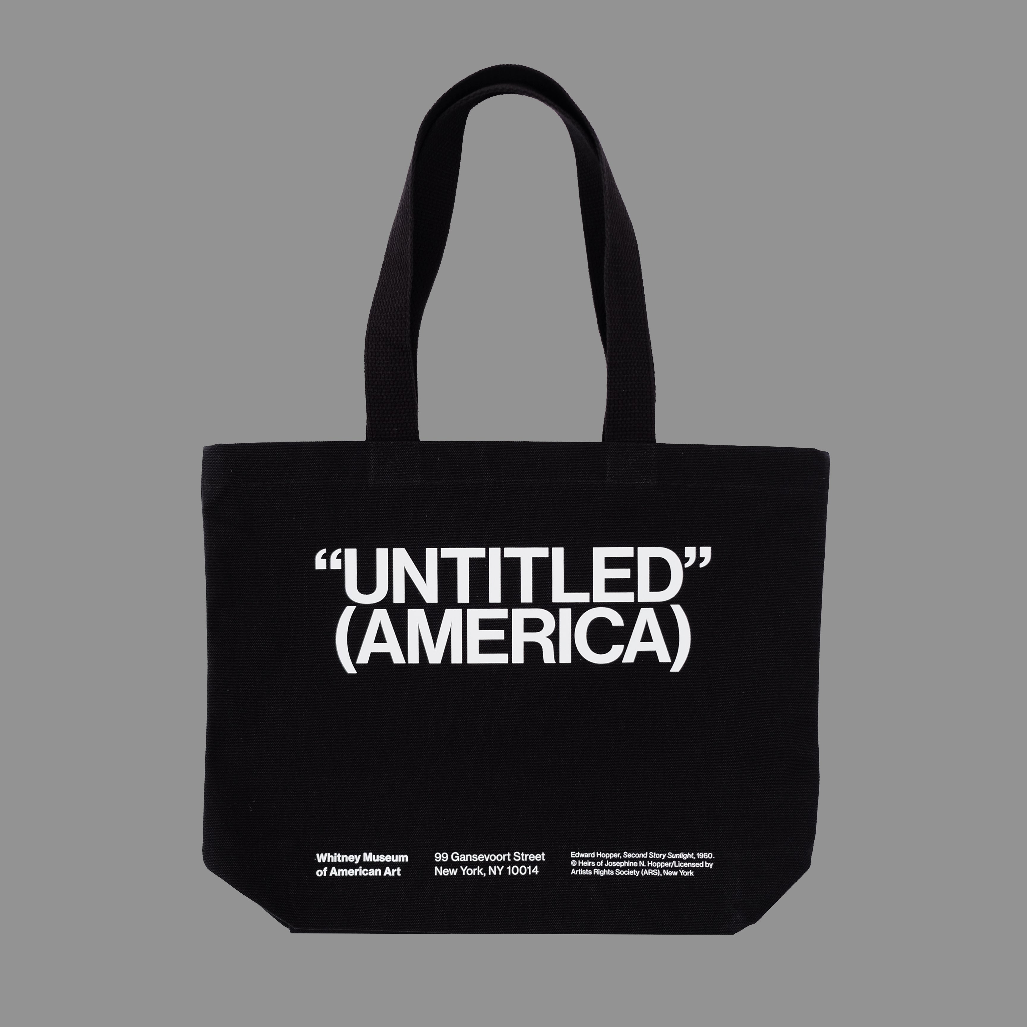 Black tote bag with 'UNTITLED (AMERICA)' text on a gray background