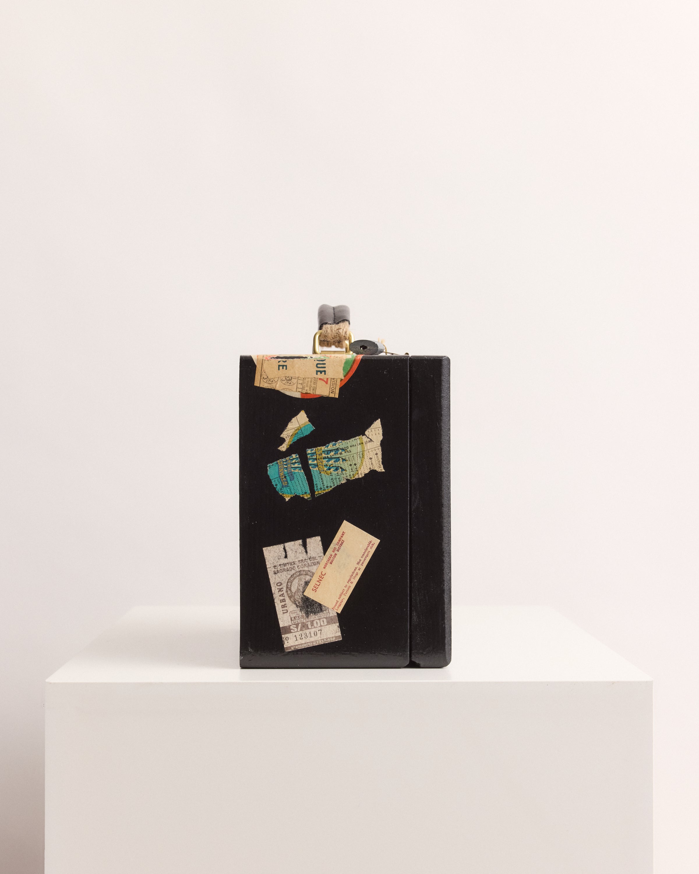 Black suitcase box with vintage ticket designs on a white background