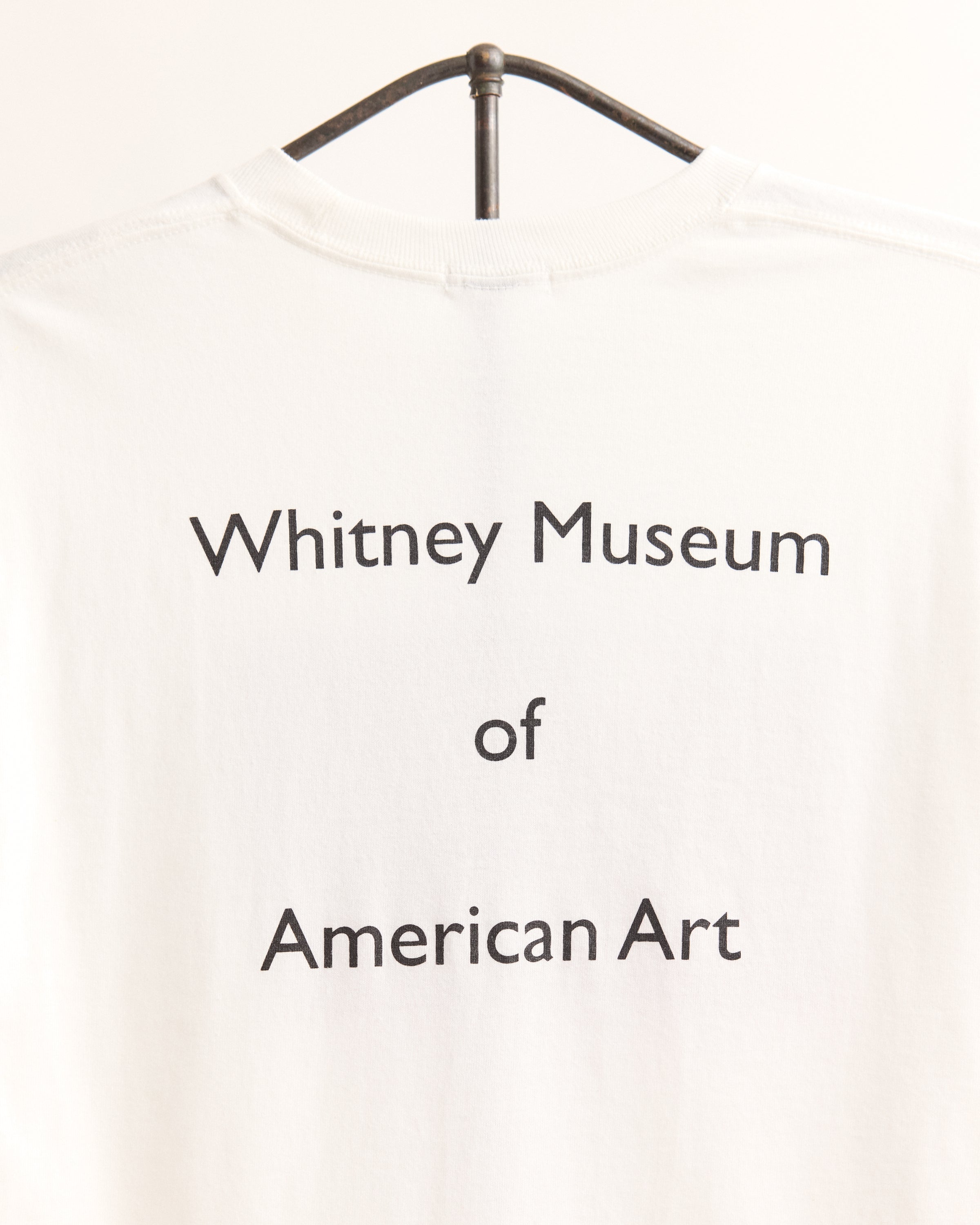 White t-shirt with 'Whitney Museum of American Art' text on a white background