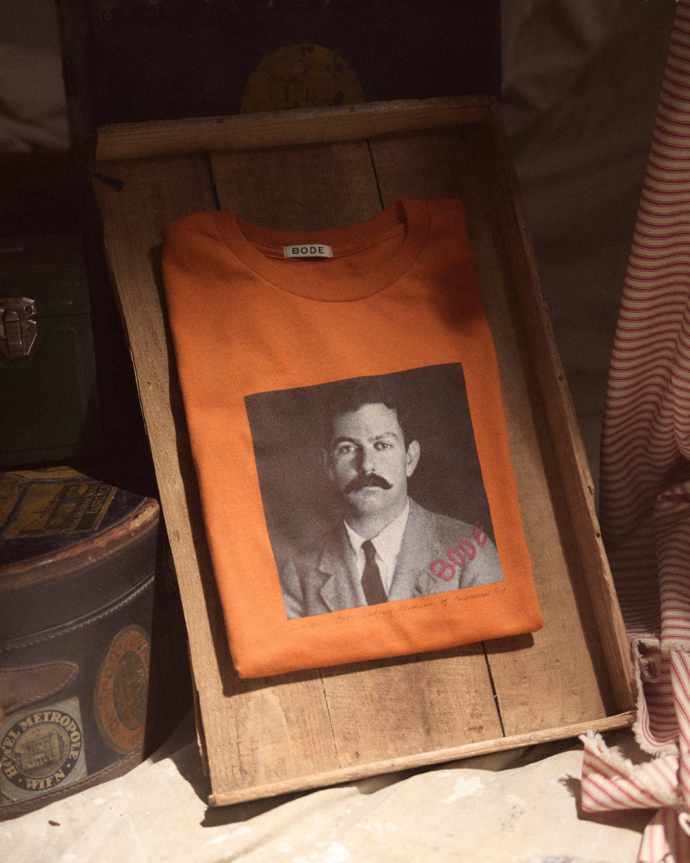 Orange t-shirt with a printed portrait on a wooden surface