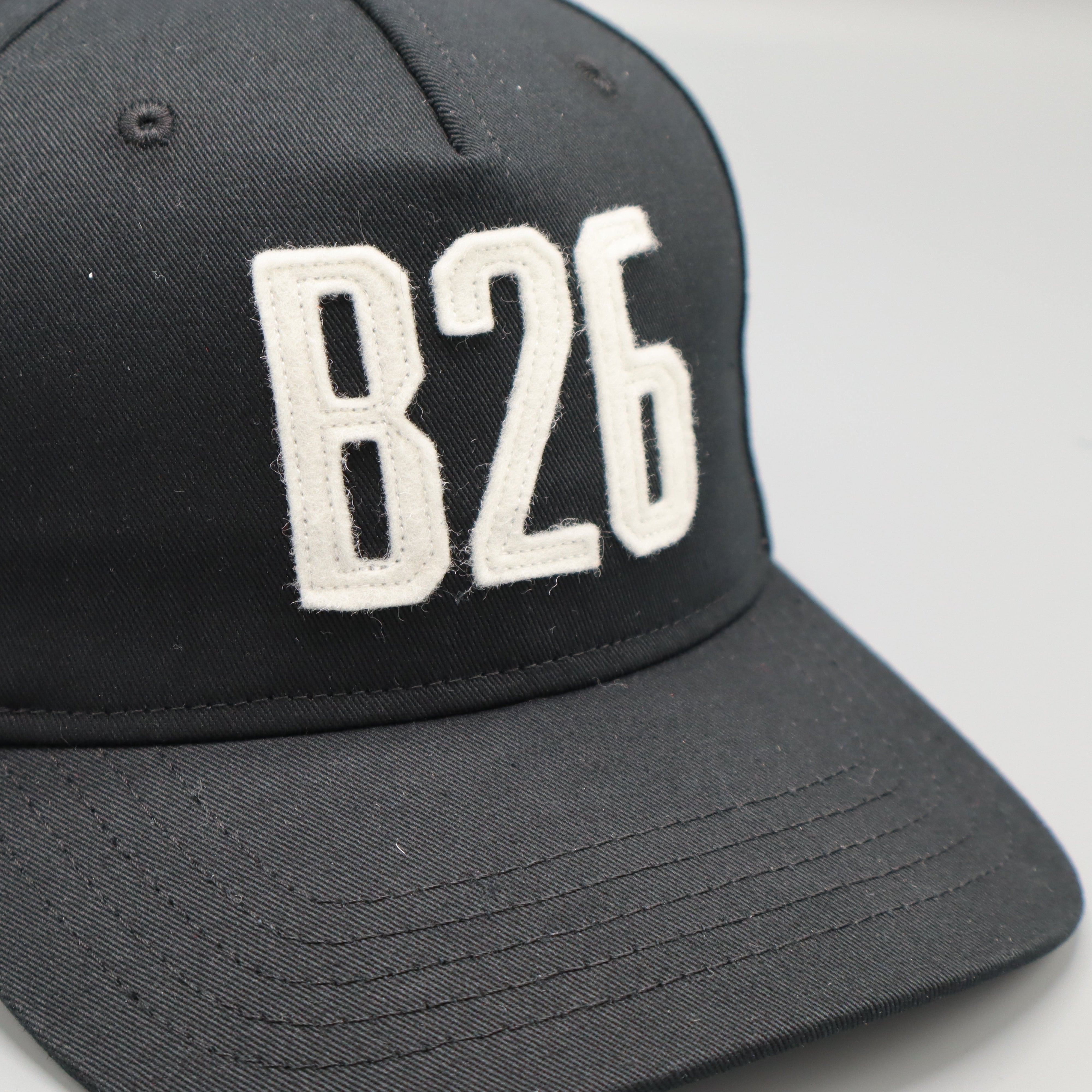 A black baseball cap with 'B26' embroidered in white block letters on the front, shown against a light gray background.