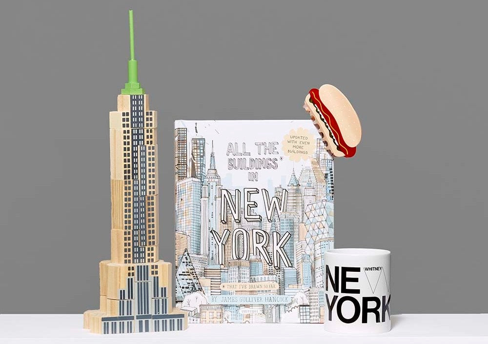 Assortment of NYC gifts including the Skyscraper Blockitecture Blocks, All the Buildings in New York: That I've Drawn So Far book, Hot Dog Hair Claw and Whitney New York Mug