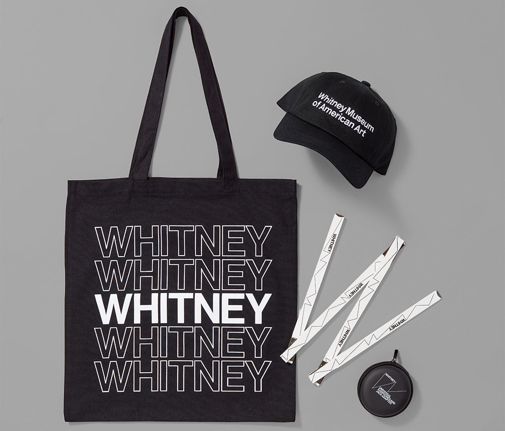 An assortment of Whitney themed products including a tote, baseball hat, ruler, and headphones