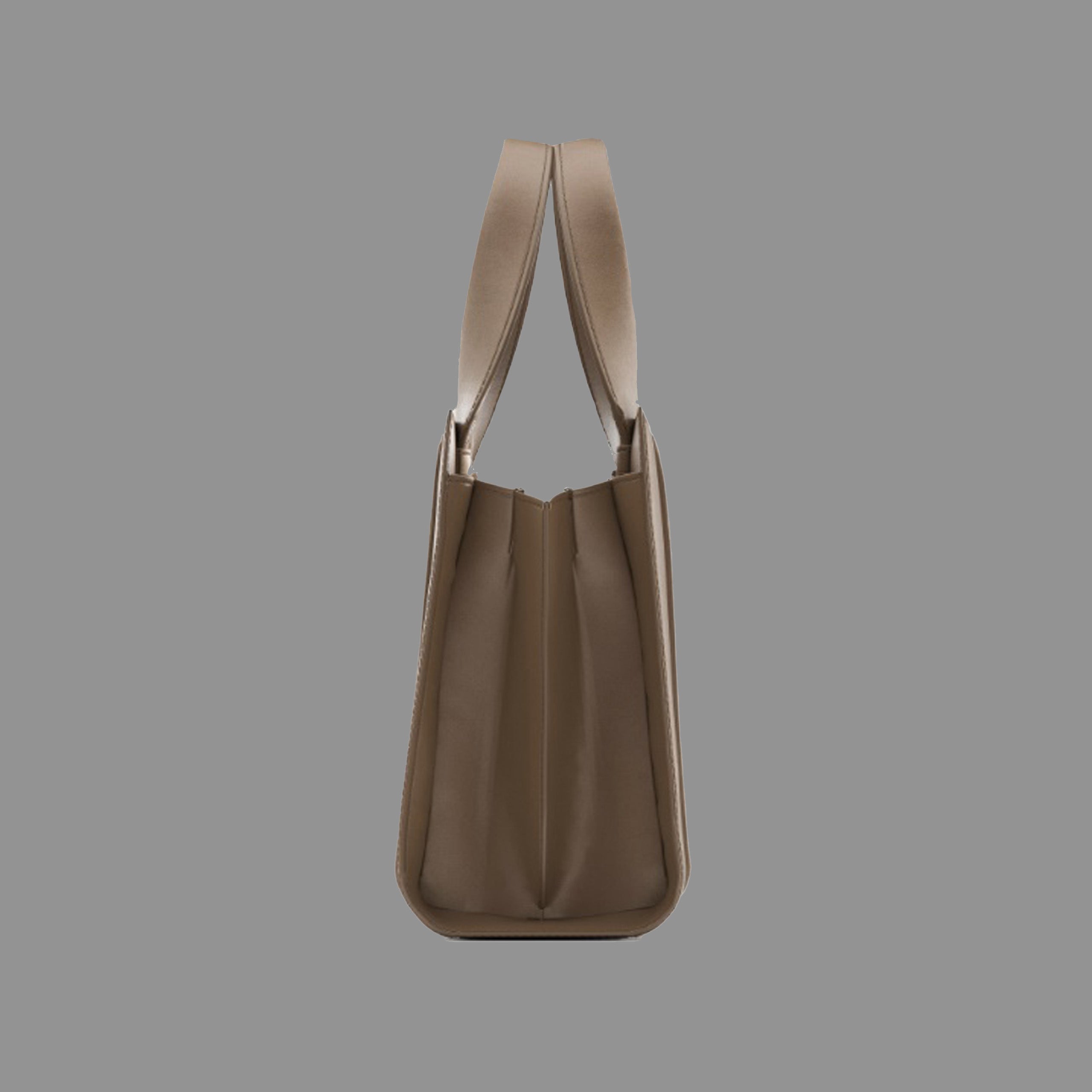 Side view of camel leather handbag with thin straps on a gray background