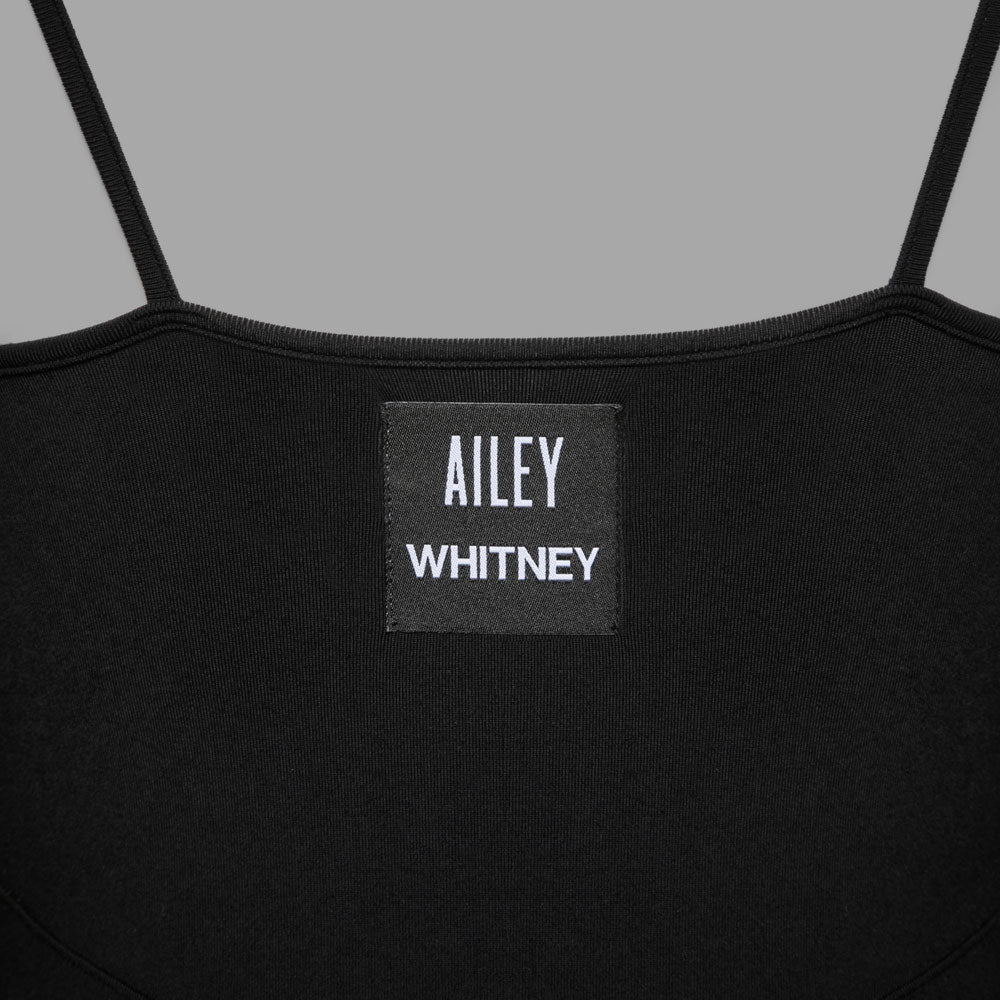 Closeup of logo tag. With delicate spaghetti straps and a sculpted bodice, this ultra-layerable leotard is crafted from a super soft, four-way stretch, sweat-wicking sport fabric that maintains its shape and hold over time.