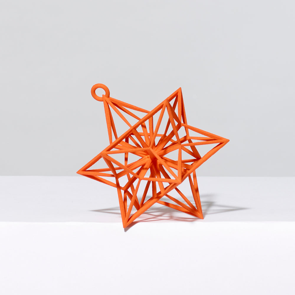 3-D printed plastic Frank Stella star ornament in orange. Measures approximately 4" x 4" x 4"