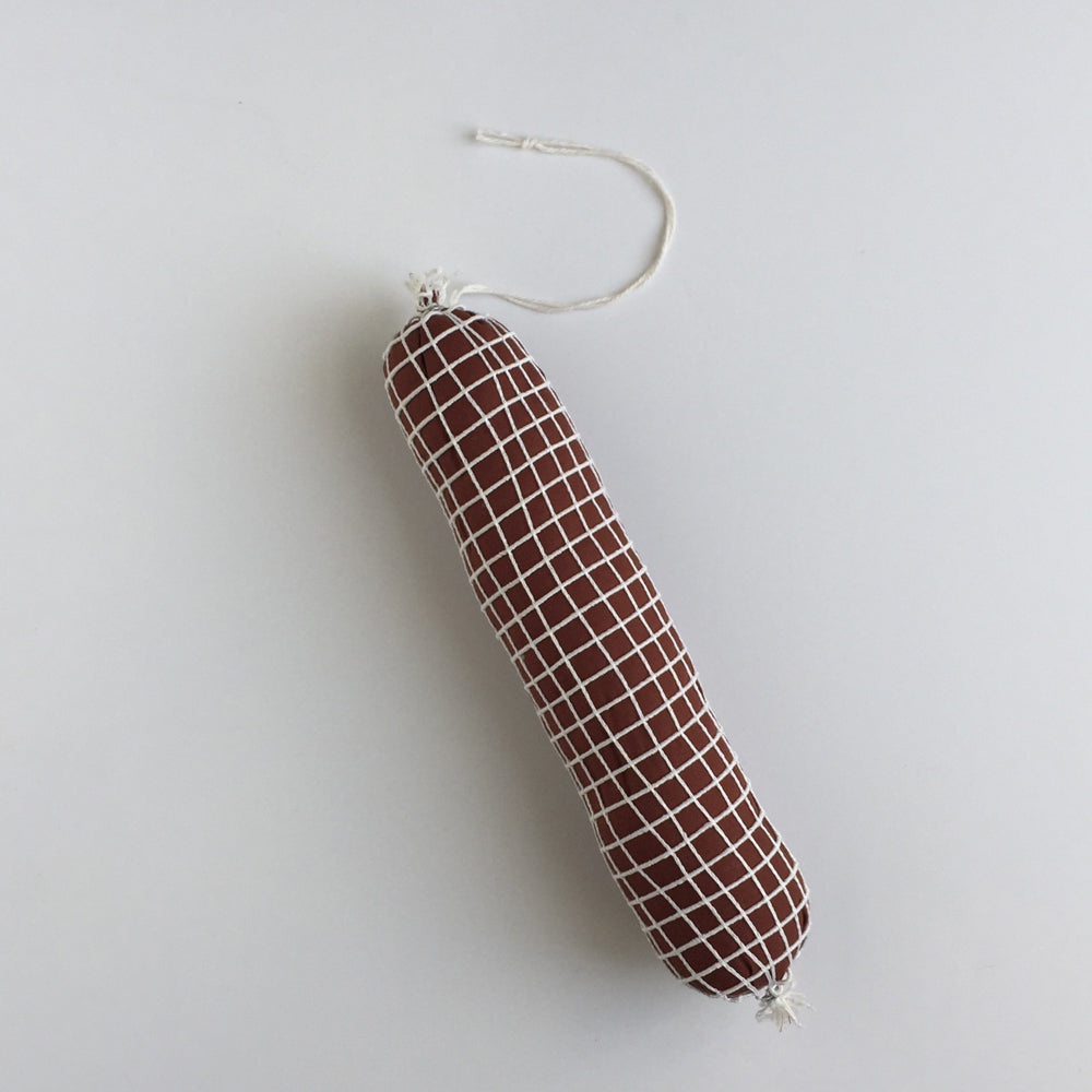 Cotton crepe, cotton thread, polyester stuffing, butcher netting Hard Salami. Measures 8" long.