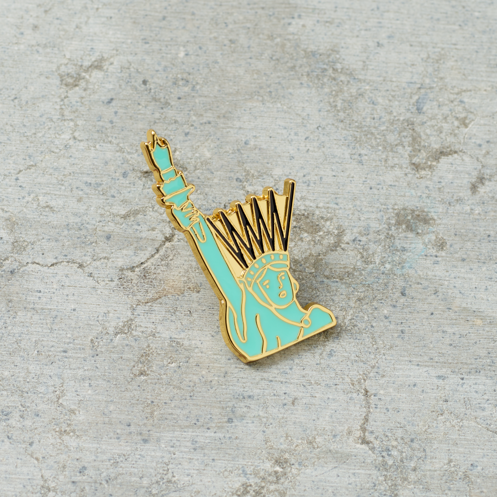 Lady Liberty hard enamel and metal pin illustrated by Tamara Shopsin.