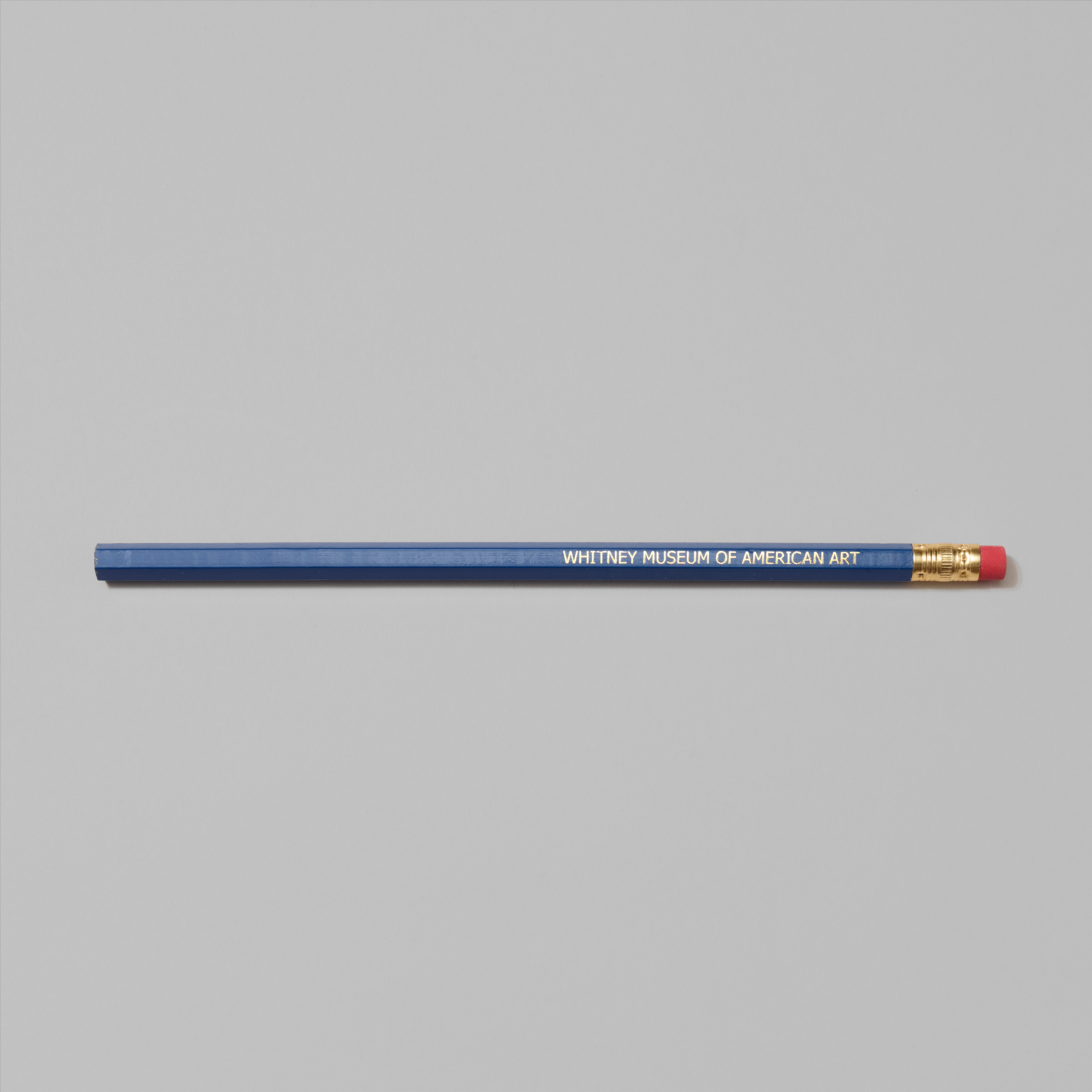 Navy blue pencil with Whitney Museum of American Art in gold foil text