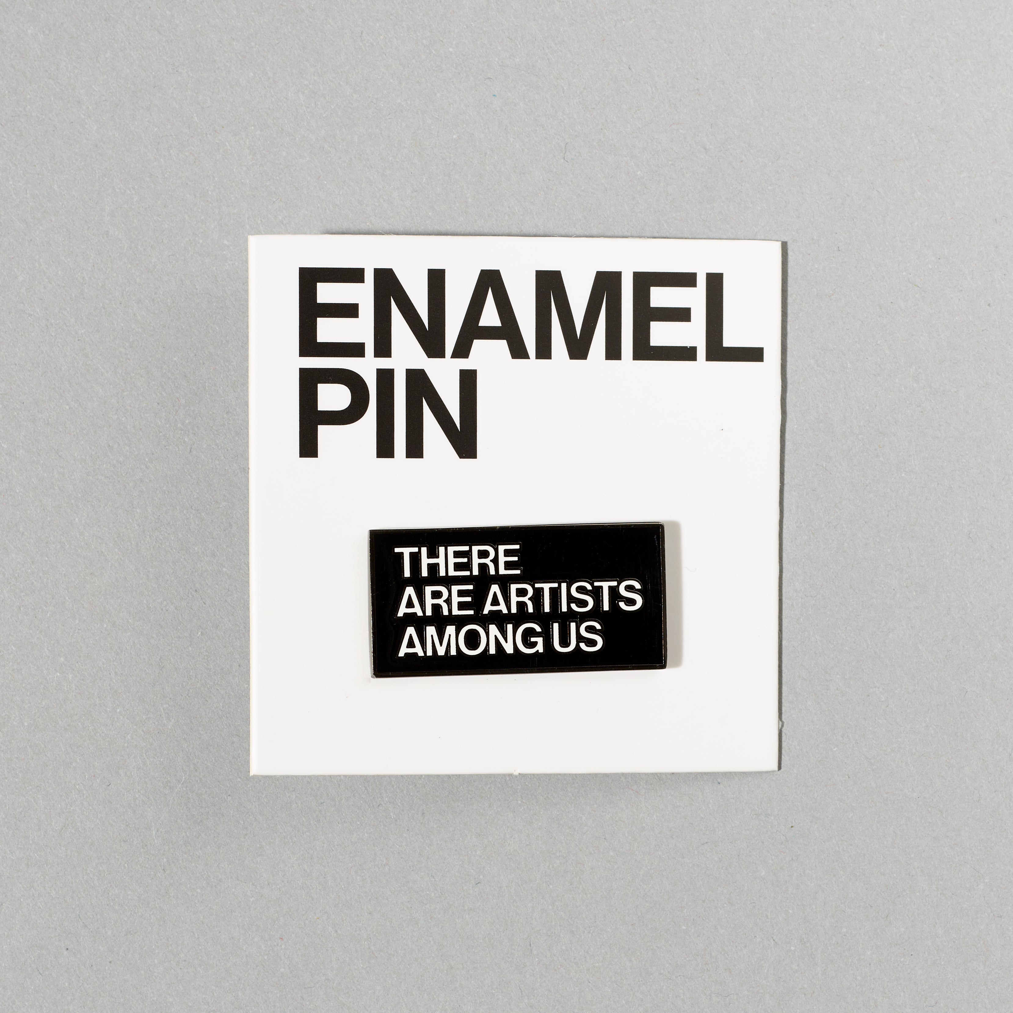 Black nickel plated brass and hard enamel pin that reads There Are Artists Among Us