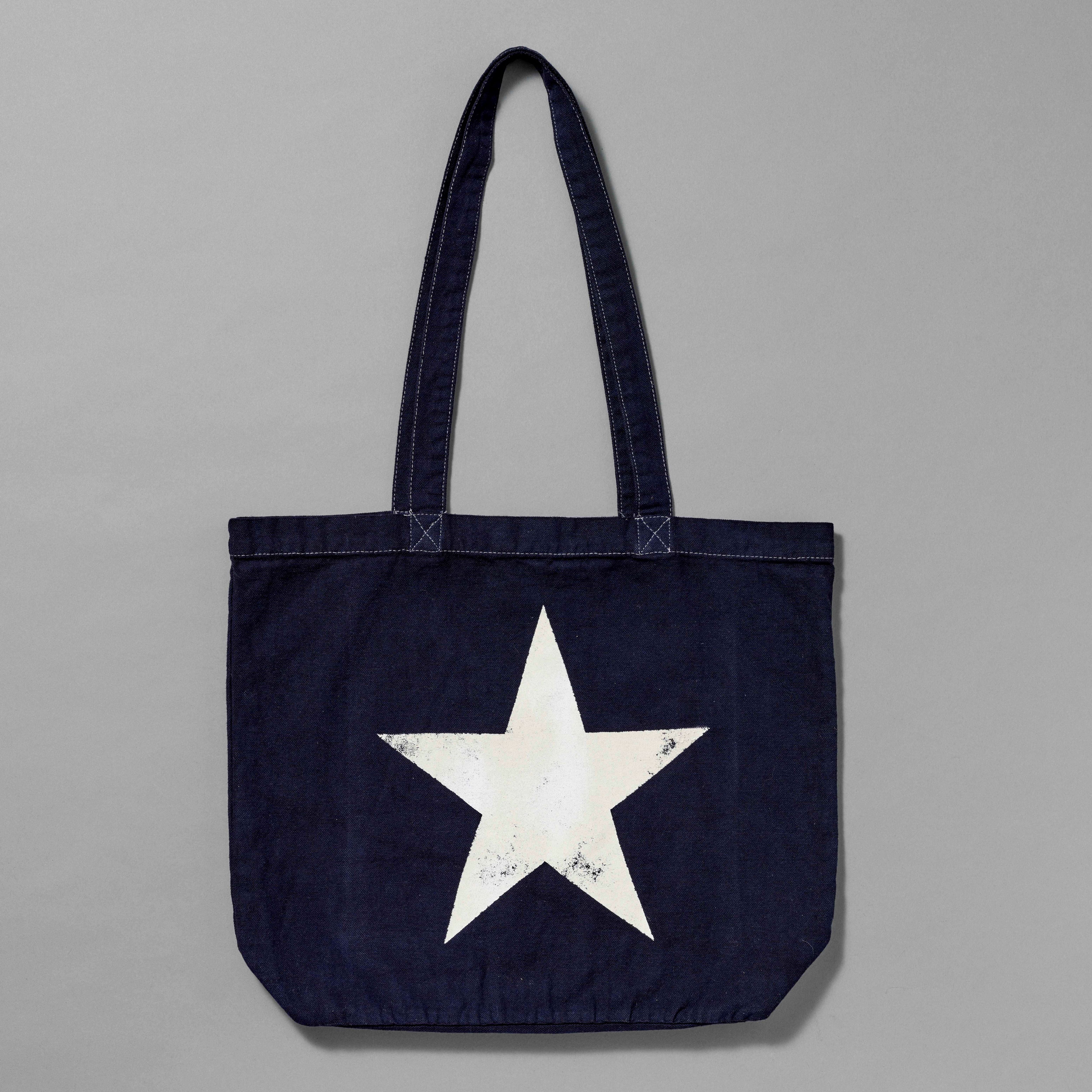 100% Organic Cotton navy tote with a white star printed. Measures 15.5" x 13". 11.5" handles