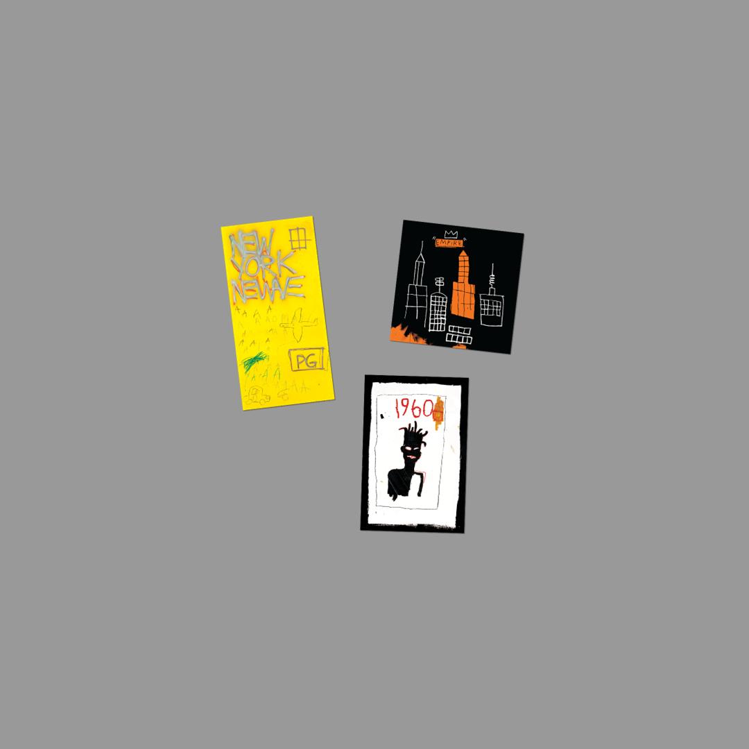 Three colorful stickers by Jean-Michel Basquiat on a gray background