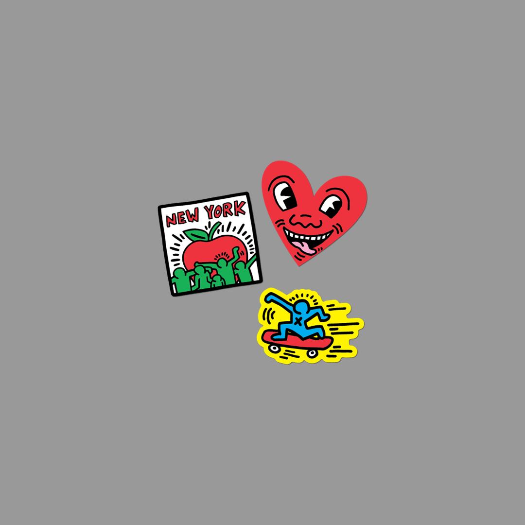 Three colorful stickers from Keith Haring on a gray background