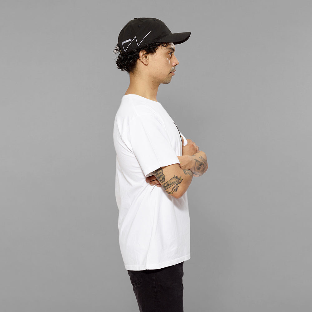Model wearing 100% cotton black cap with white Whitney logo on right side