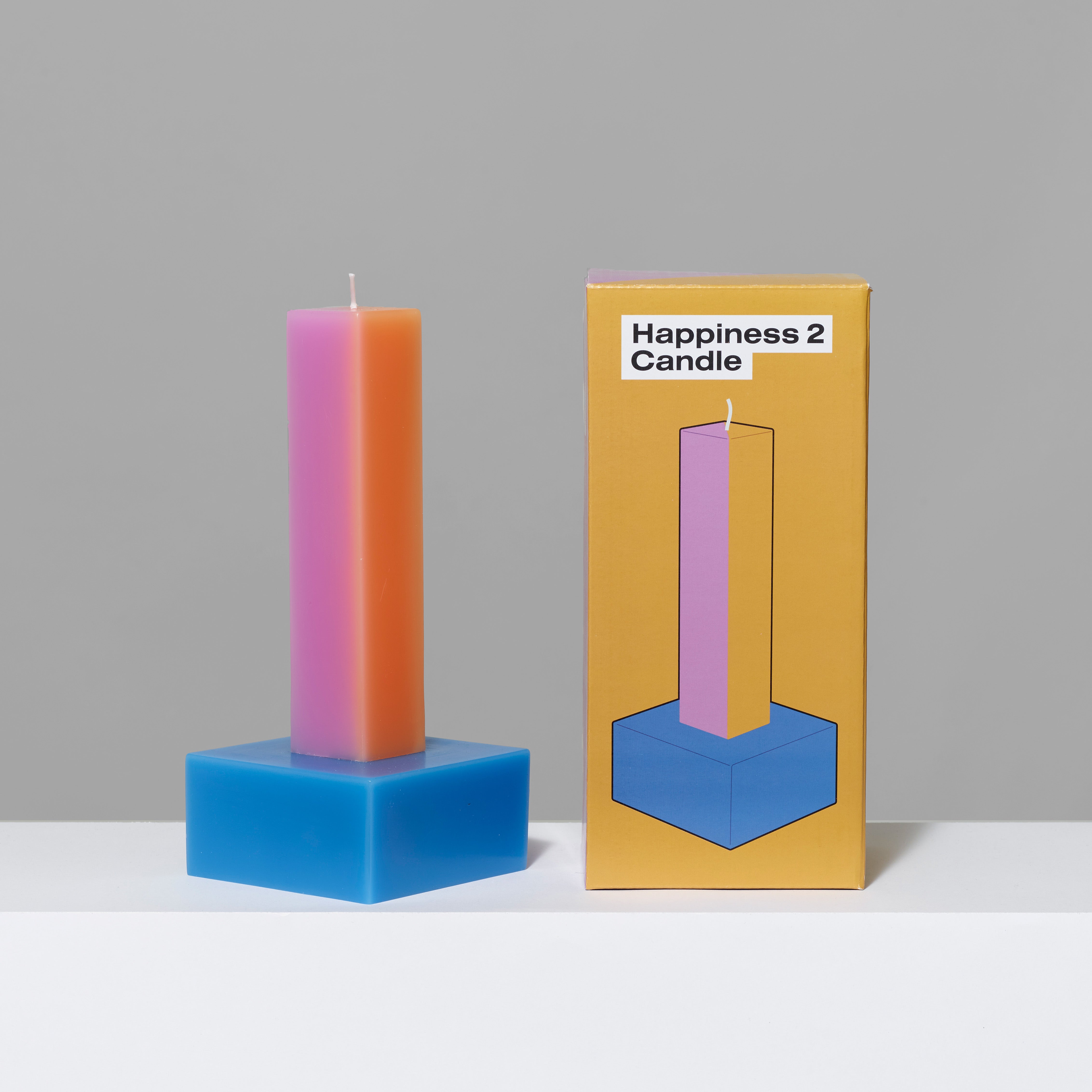 Paraffin wax Orange/Pink Happiness Pillar Candle and box. Measures 4" x 4" x 9".