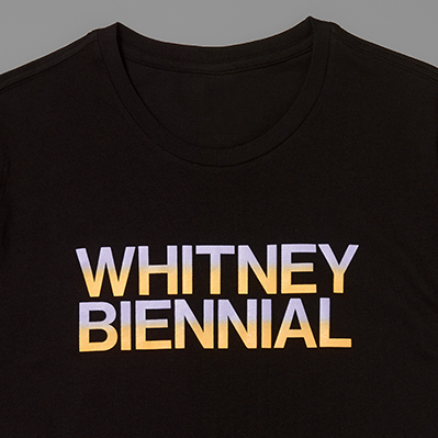 Black t-shirt with 'WHITNEY BIENNIAL' text in purple and orange on a gray background
