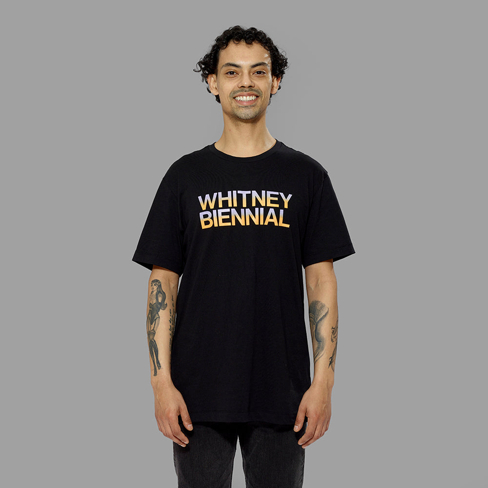 Model wearing 100% cotton black t-shirt with Whitney Biennial screen printed in purple and orange gradient colors