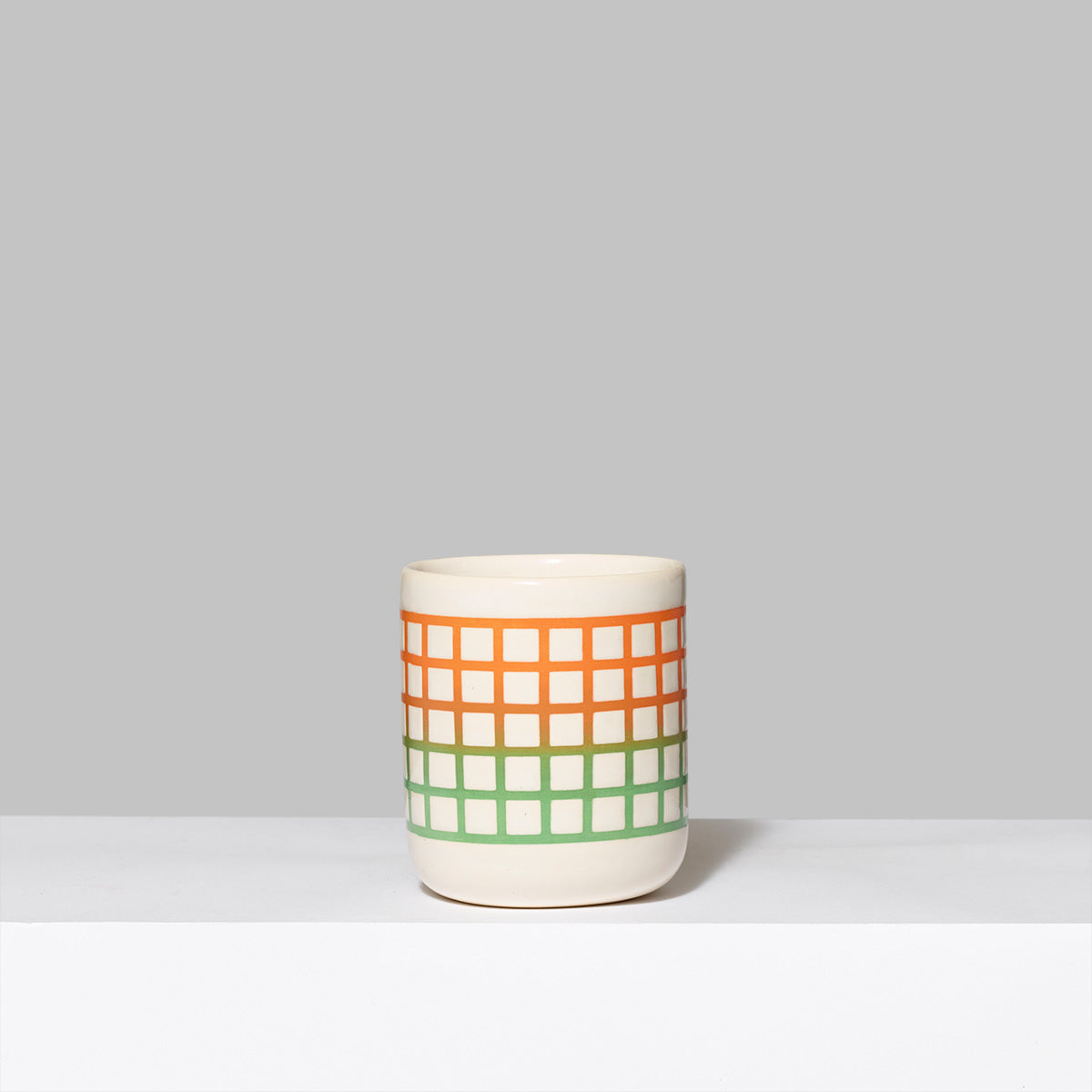 Handmade stoneware and glaze Biennial tumbler in green and orange. Measures 3" L x 3" W x 3.5" H