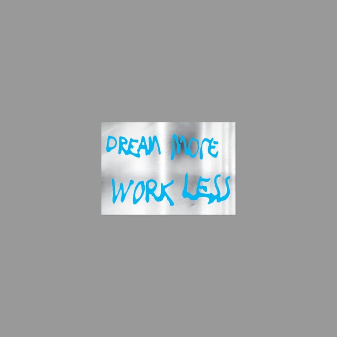 Motivational sticker with 'Dream More Work Less' text on a gray background