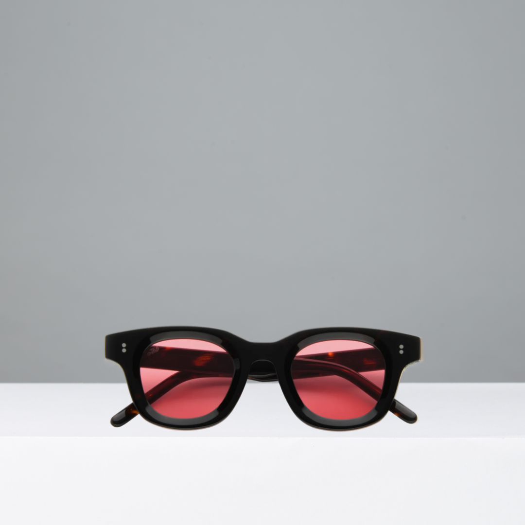 Black sunglasses with red lenses on a gray background