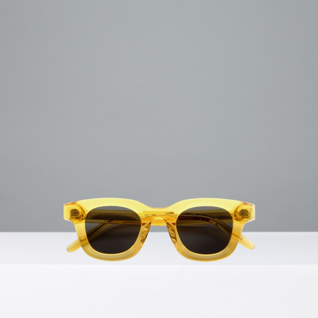 Yellow sunglasses on a gray background