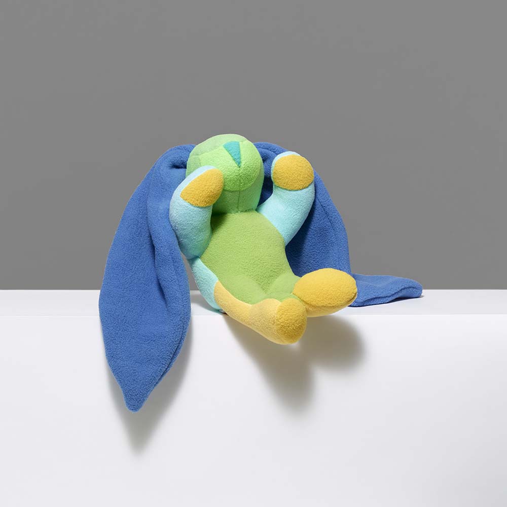 Colorful toy resembling a bunny rabbit with blue, green, and yellow colors on a gray background