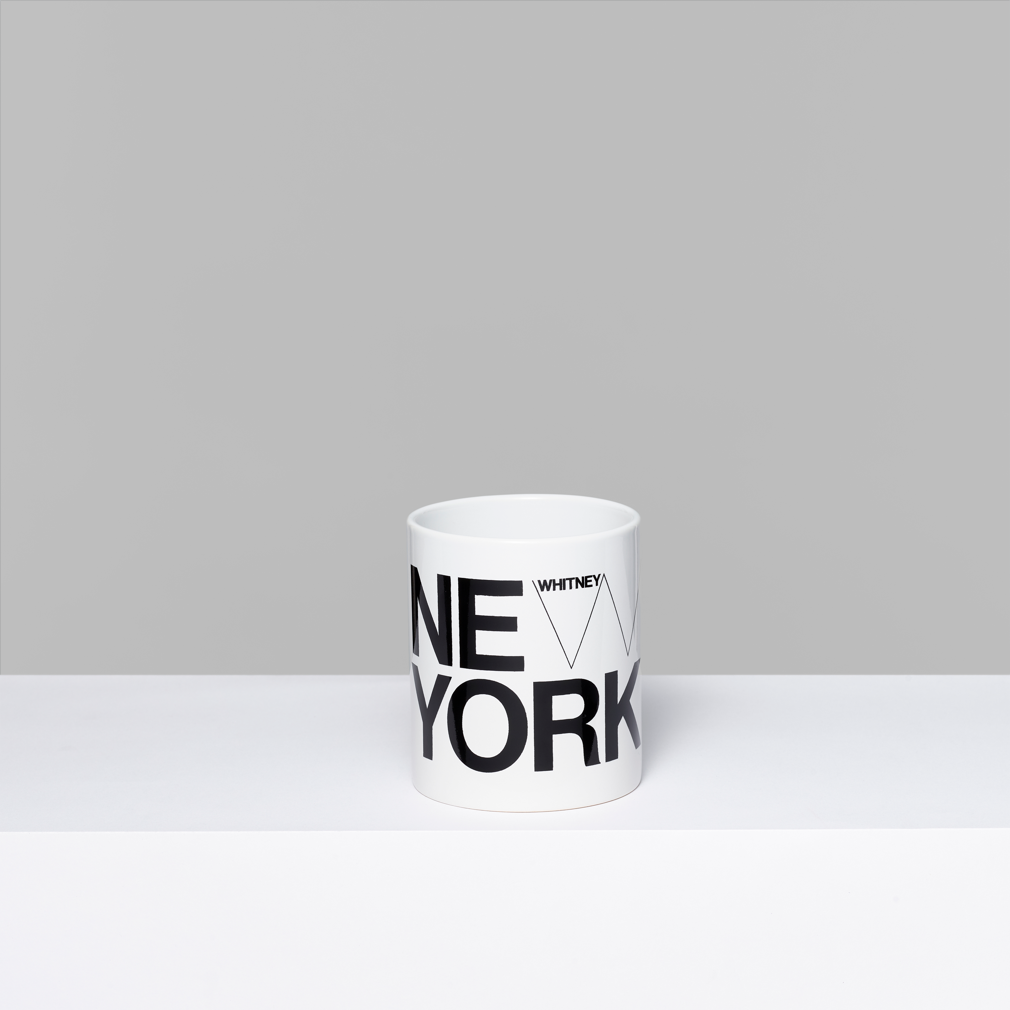 Whitney New York white ceramic mug with New York and the Whitney logo in black text. Measures 3.75" x 3"