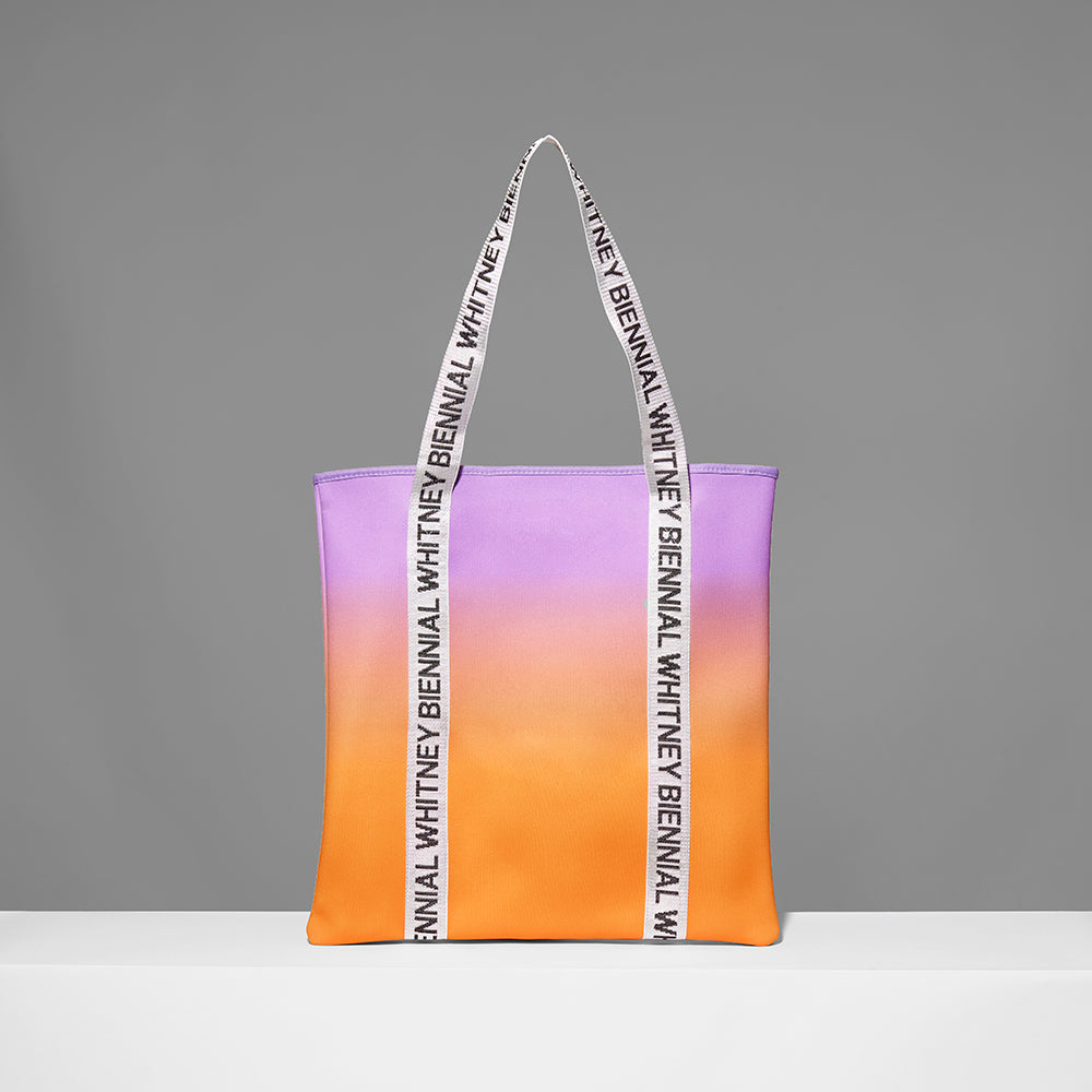 100% neoprene gradient tote featuring the Whitney Biennial in repeat text on the handles. Measures 16" x 17". 3.5" gusset, 11" handles.