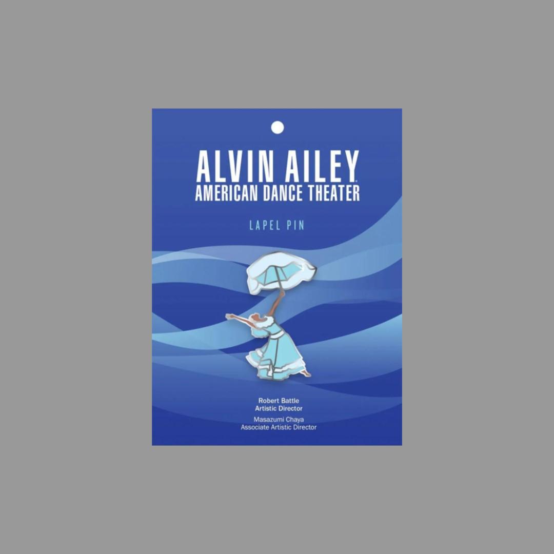 Alvin Ailey enamel pin featuring a dancer in a blue dress holding an umbrella