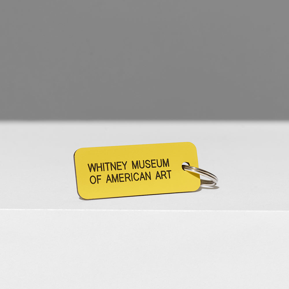 100% acrylic yellow keychain with Whitney Museum of American Art in black text