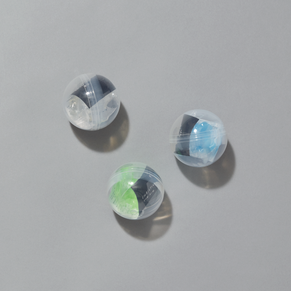 Three transparent balls with colorful sticky hands on a gray background