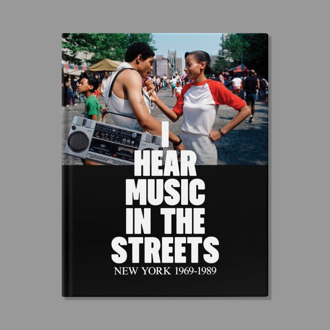 Book cover with two people by a boombox and text 'I Hear Music in the Streets New York 1969-1989' on a gray background