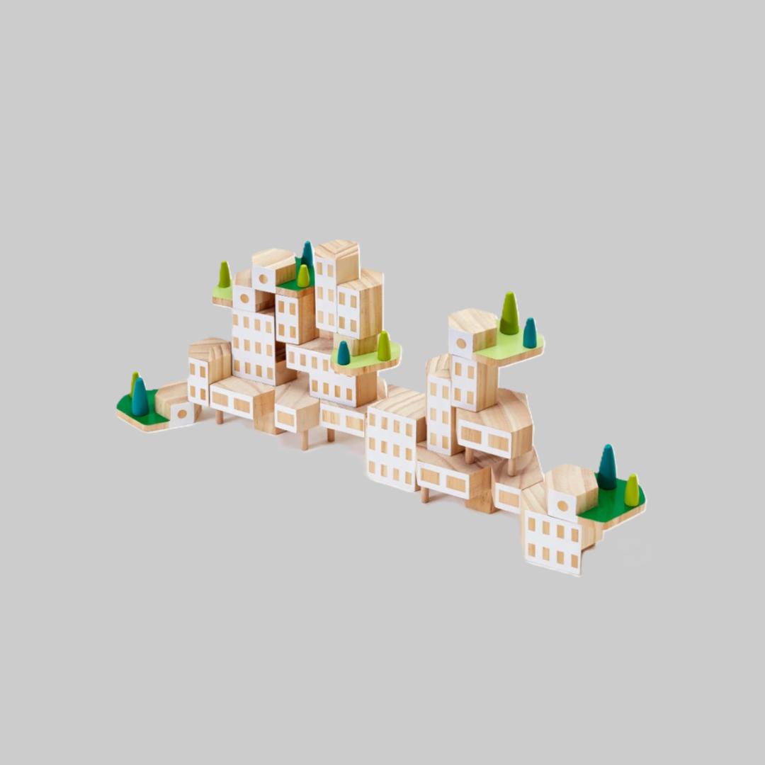 Wooden block toy cityscape with trees on a light gray background