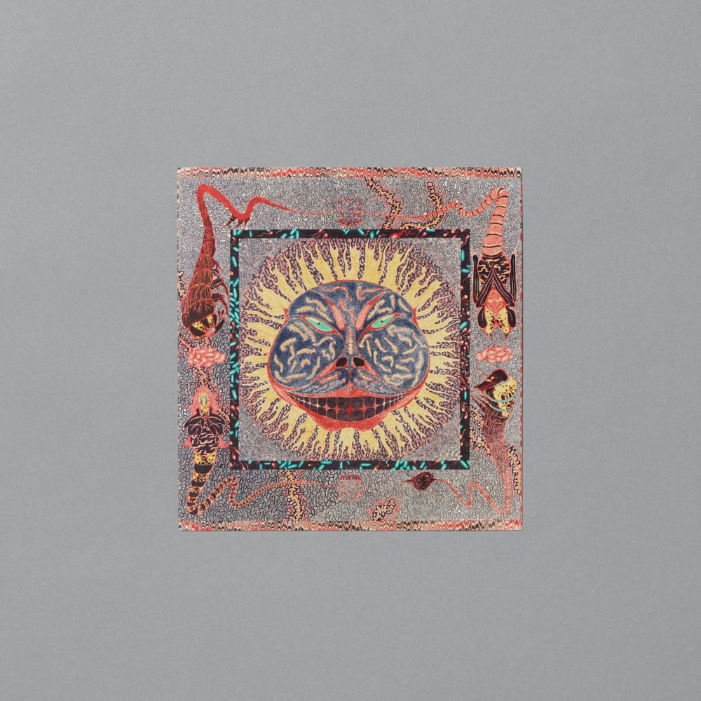Postcard featuring decorative piece with a central sun-like design surrounded by abstract elements on a gray background