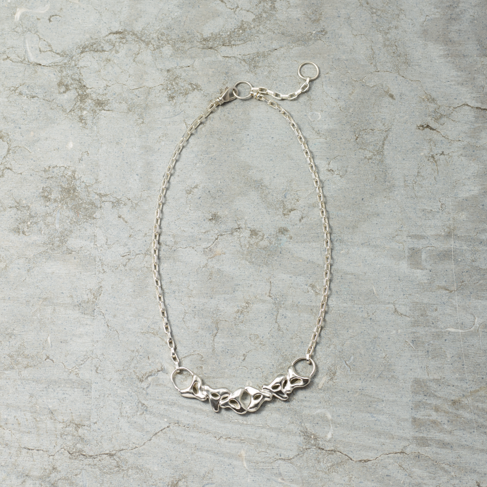 Silver necklace on a textured gray surface