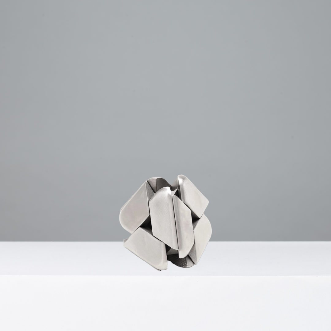 Triangular silver geometric puzzle on a gray background