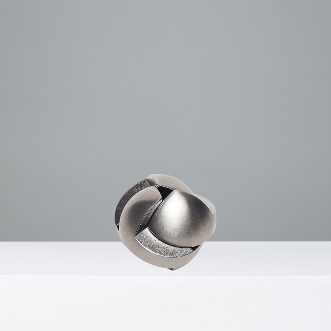Metallic puzzle ball on a gray background
