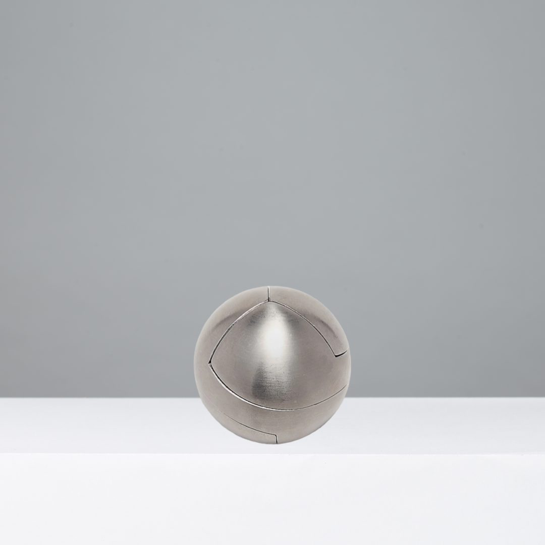 Metallic puzzle ball on a gray background