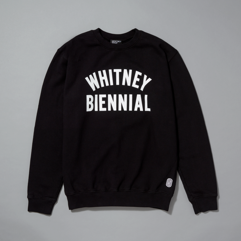 Black sweatshirt with 'WHITNEY BIENNIAL' white text on a gray background