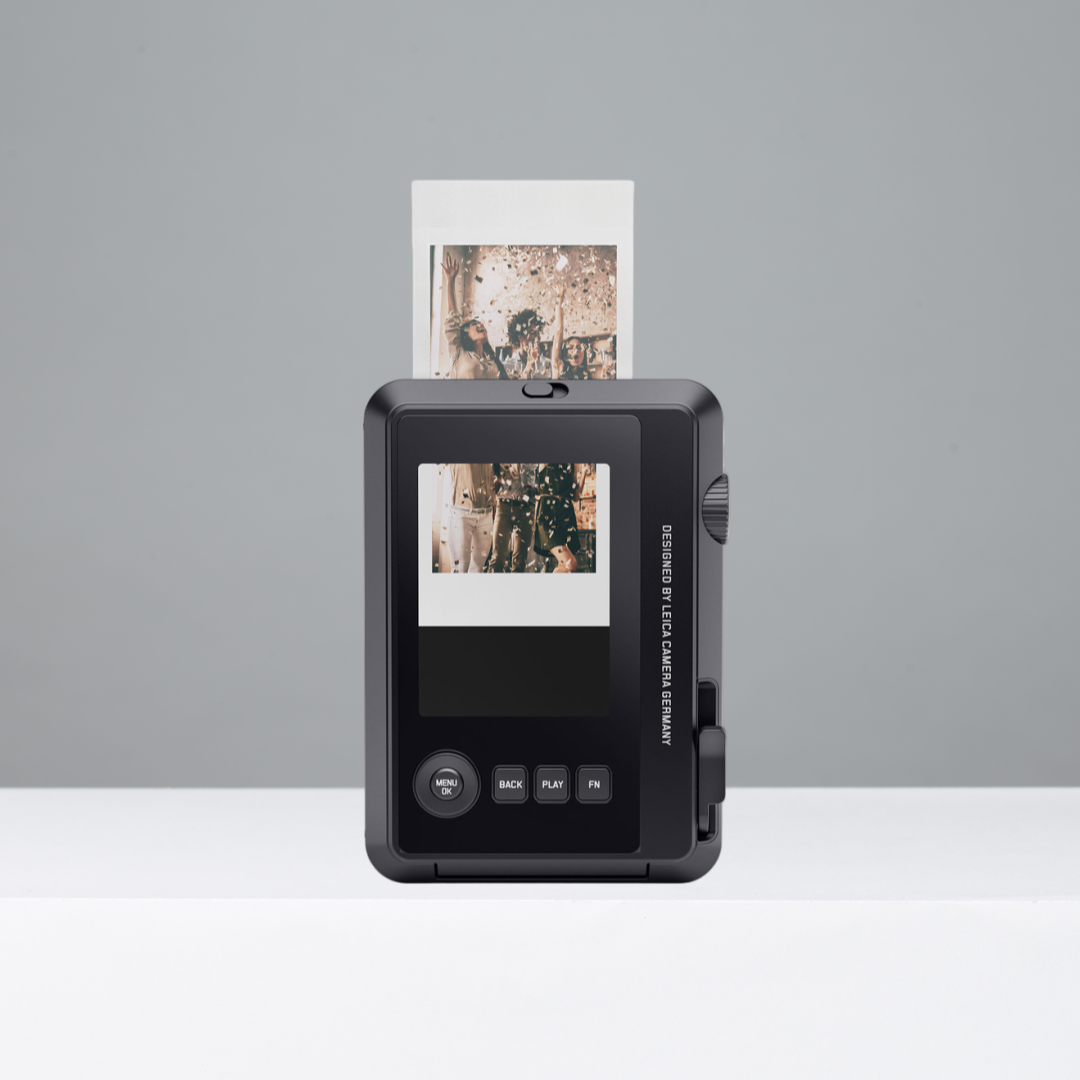 Black Leica Sofort 2 instant camera on a gray background