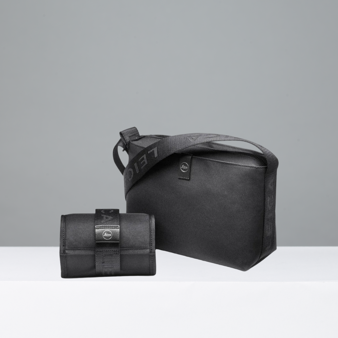 Black crossbody bag and camera pouch on a white ledge