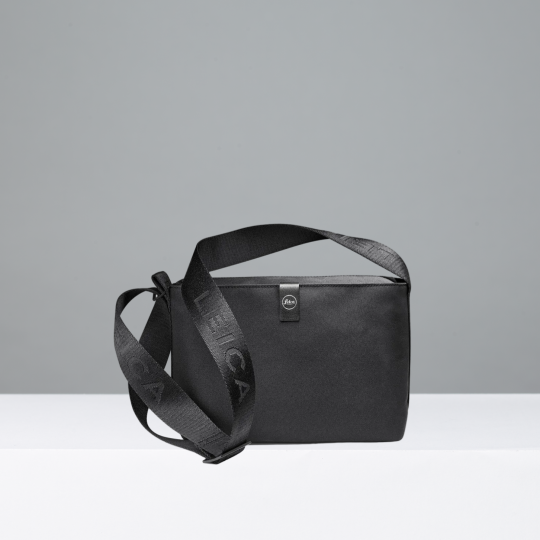 Black crossbody bag with a visible Leica brand logo on a white background