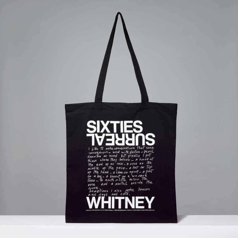 Black tote bag with white text on a gray background
