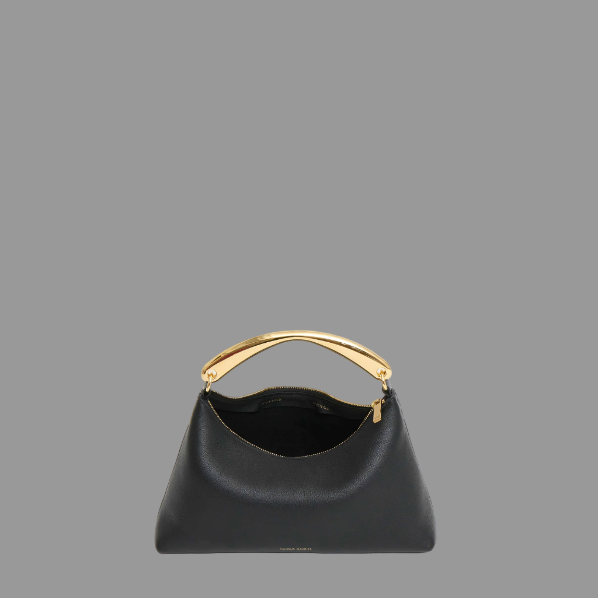 Black leather bag with gold handle on a grey background