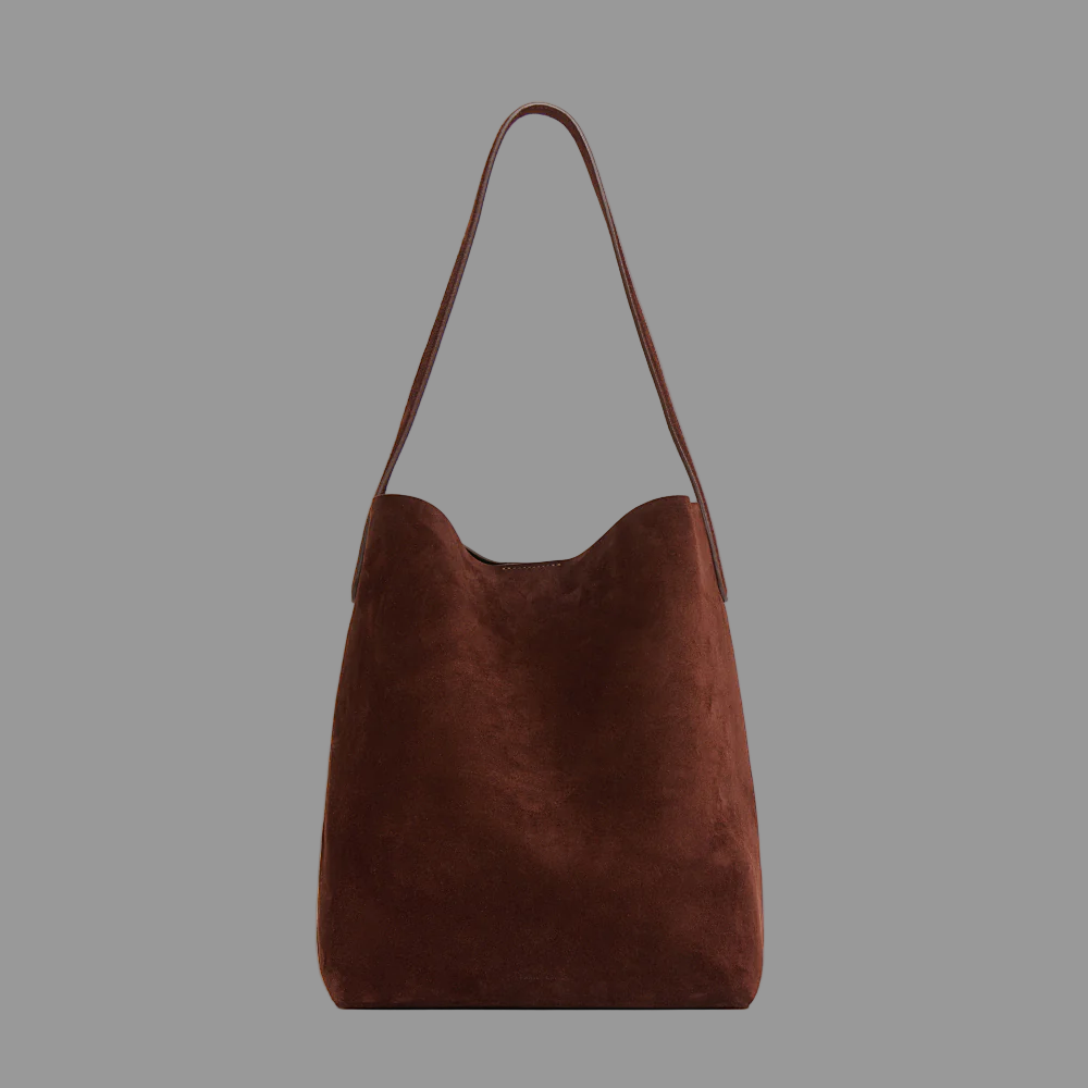 Chocolate suede leather bag on a grey background