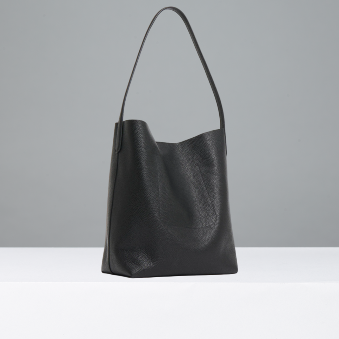 Black leather handbag on a light gray background