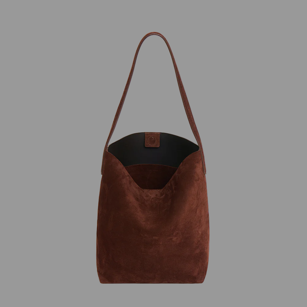 Chocolate suede leather bag on a grey background