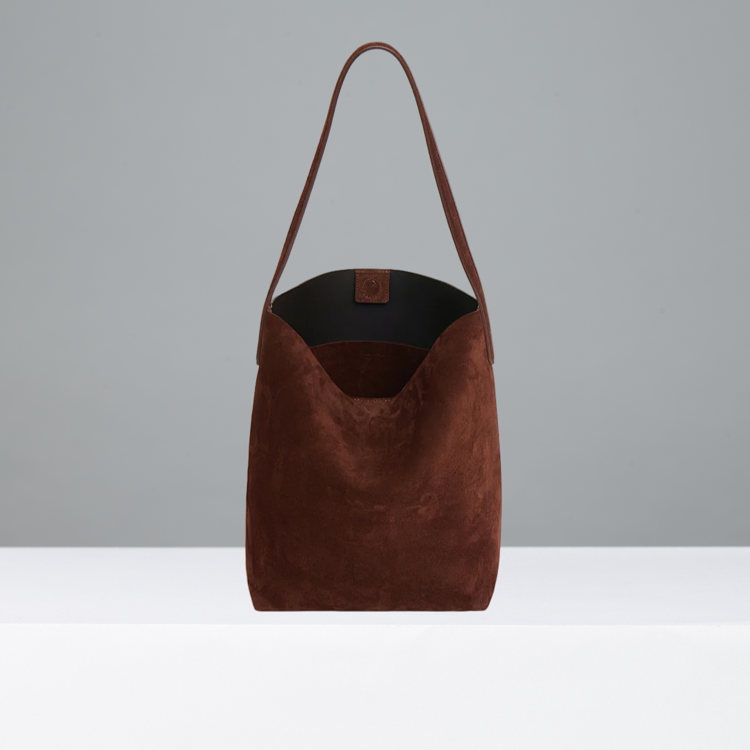 Chocolate suede leather bag on a grey background